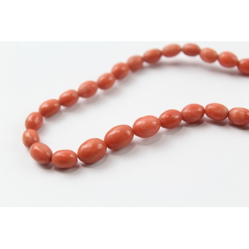 483 - 9ct gold clasped coral bead necklace and a carved coral stick pin (17.4g)