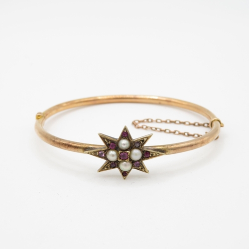 426 - 14ct gold ruby and seed pearl set starburst bangle (7.9g)