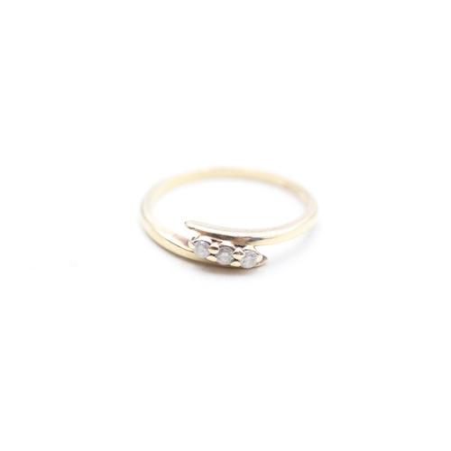 131 - 9ct gold diamond set delicate trilogy bypass ring (1.4g) Size L