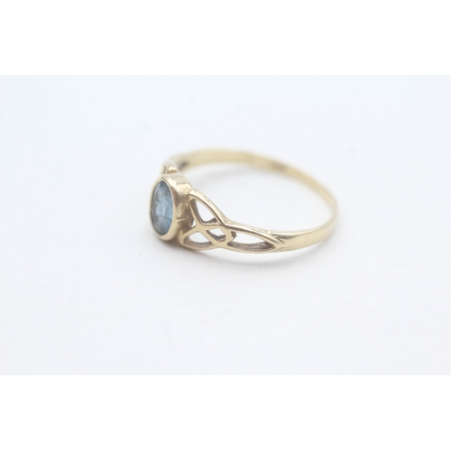 190 - 9ct gold blue topaz set Celtic dress ring (1.3g) Size M