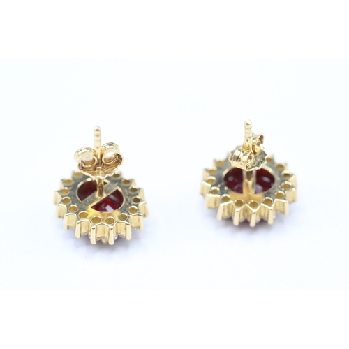 229 - 18ct gold diamond & glass filled ruby oval cluster stud earrings (5.6g)