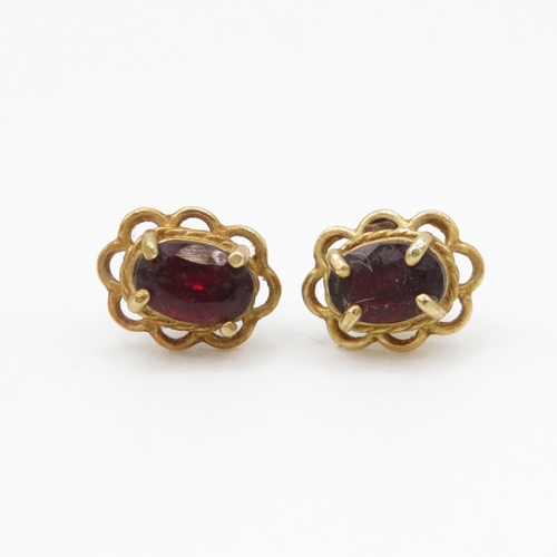 69 - 9ct gold oval cut garnet stud earrings (1g)