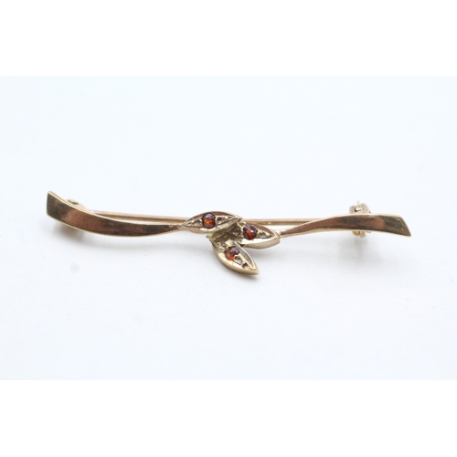 143 - 9ct gold garnet three stone brooch (1.5g)