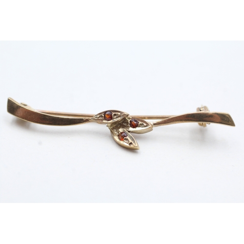 143 - 9ct gold garnet three stone brooch (1.5g)