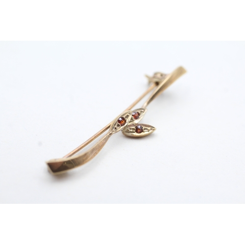 143 - 9ct gold garnet three stone brooch (1.5g)