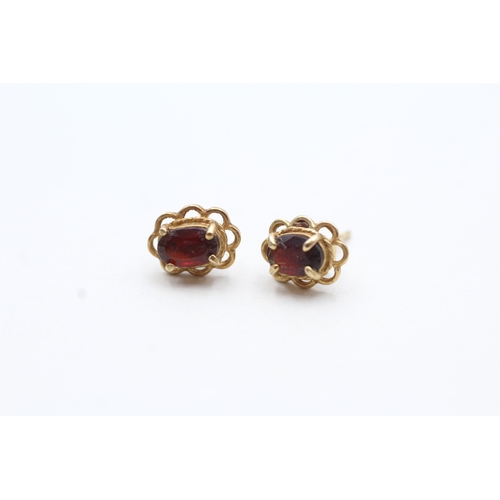 69 - 9ct gold oval cut garnet stud earrings (1g)