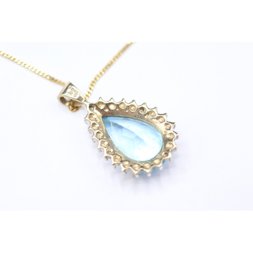 169 - 9ct gold pear cut blue gemstone and diamond pendant on chain (3.7g)