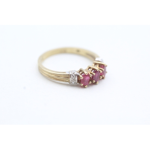 175 - 9ct gold ring with three pink gemstones and diamond set shoulders (2.3g) Size O