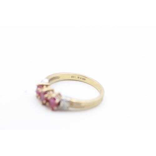 175 - 9ct gold ring with three pink gemstones and diamond set shoulders (2.3g) Size O