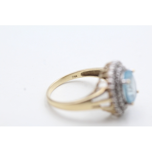 199 - 9ct gold ring with central blue gemstone surrounded by diamonds (3.9g) Size Q