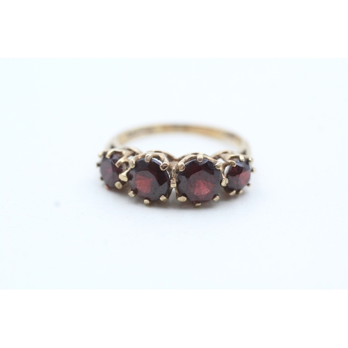 66 - 9ct gold four round cut red gemstone ring (3g) Size M