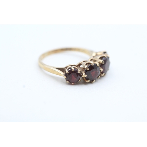 66 - 9ct gold four round cut red gemstone ring (3g) Size M