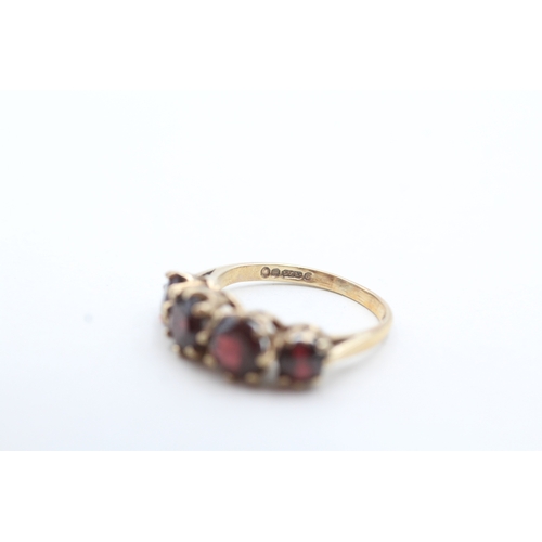 66 - 9ct gold four round cut red gemstone ring (3g) Size M