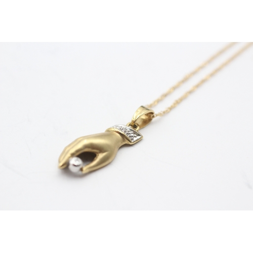 91 - 18ct gold hand diamond pendant on chain (3.2g)