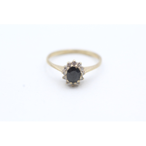 92 - 9ct gold ring with central blue gemstone surrounded by set diamonds (1.6g) Size M