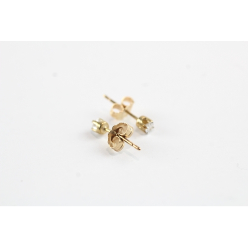 216 - 10ct gold single diamond stud earrings