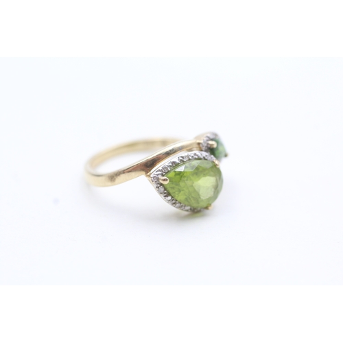 203 - 9ct gold diamond and green gemstone bypass ring (2.7g) Size L 1/2