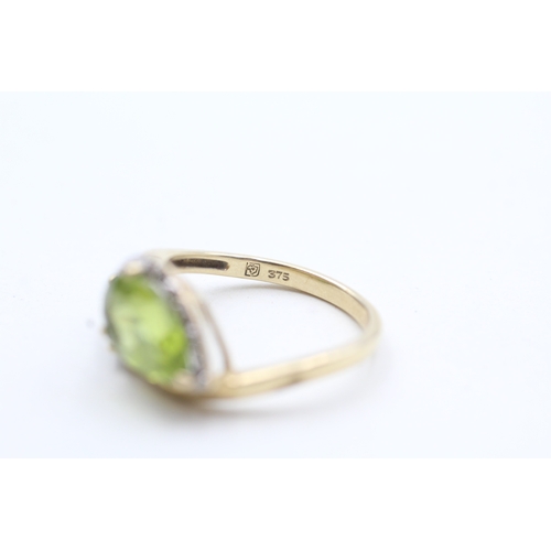 203 - 9ct gold diamond and green gemstone bypass ring (2.7g) Size L 1/2