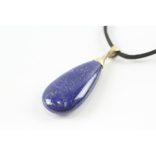 72 - 9ct gold lapis lazuli pendant necklace on a black cord (11.4g)