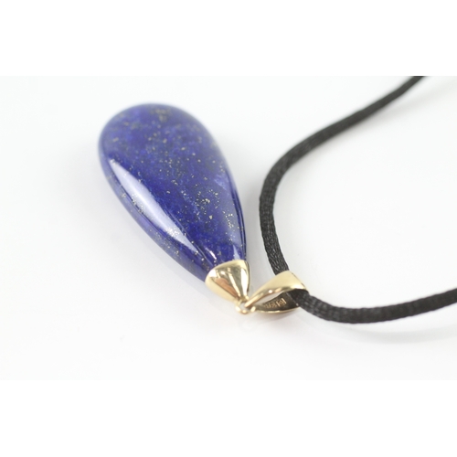 72 - 9ct gold lapis lazuli pendant necklace on a black cord (11.4g)