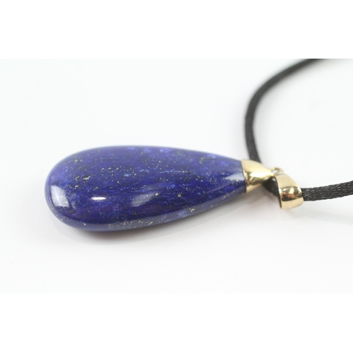 72 - 9ct gold lapis lazuli pendant necklace on a black cord (11.4g)