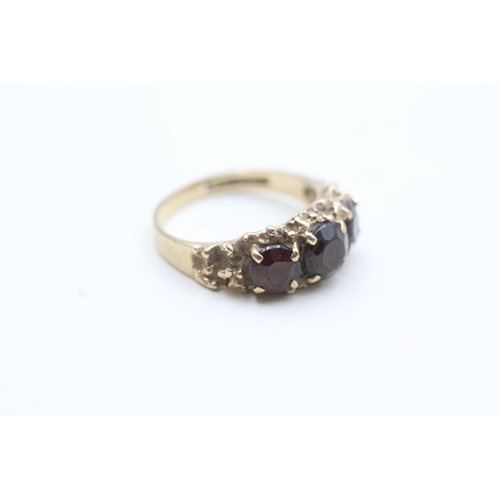 101 - 9ct gold garnet three stone ring (3.6g) Size N