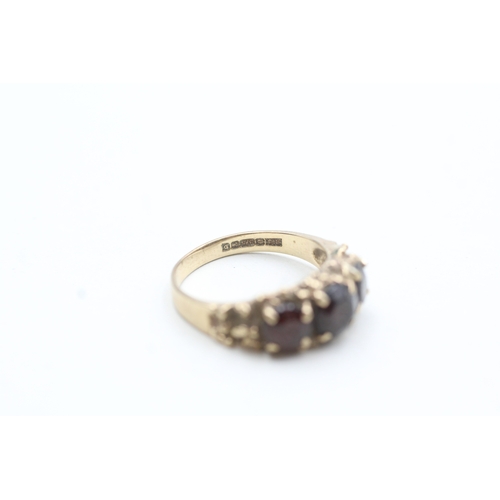 101 - 9ct gold garnet three stone ring (3.6g) Size N