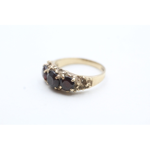 101 - 9ct gold garnet three stone ring (3.6g) Size N