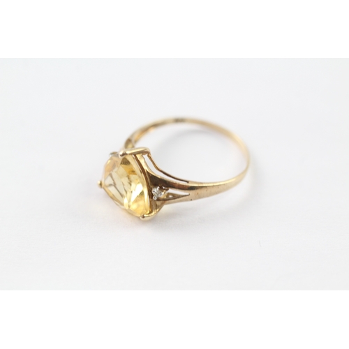 223 - 9ct gold diamond and yellow gemstone three stone ring (1.5g) Size O