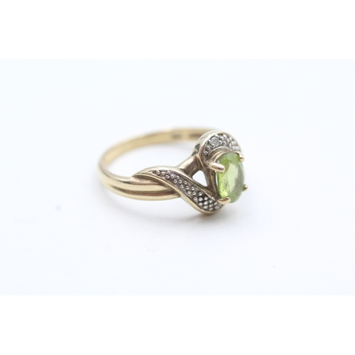 152 - 9ct gold peridot and diamond halo twist ring (2.5g) Size N