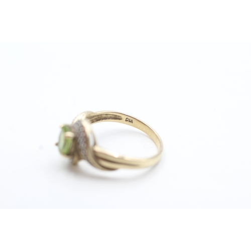 152 - 9ct gold peridot and diamond halo twist ring (2.5g) Size N