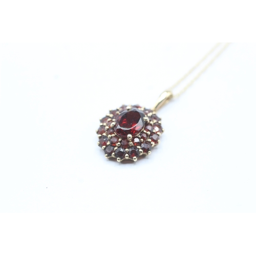 101 - 9ct gold garnet double halo pendant on chain (2.4g)