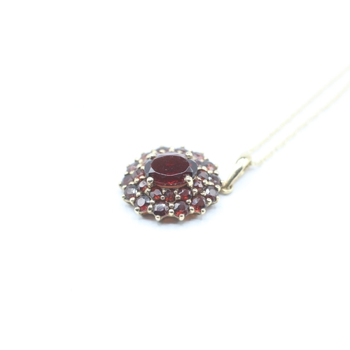 101 - 9ct gold garnet double halo pendant on chain (2.4g)