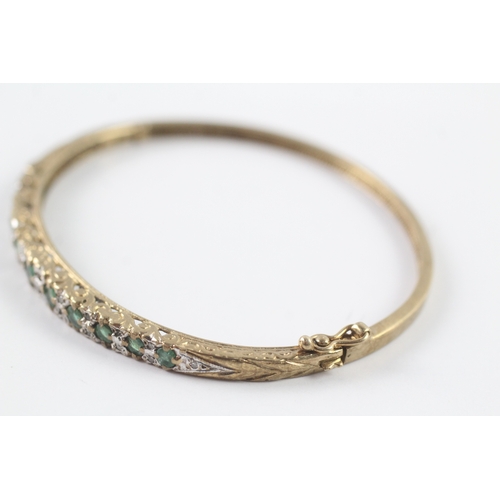 249 - 9ct gold emerald and diamond bangle (12.2g)