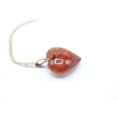 51 - 9ct gold amber heart pendant on chain (2.6g)