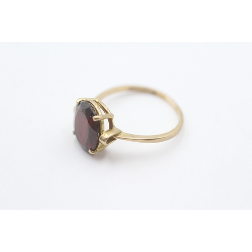 214 - 9ct gold oval claw set garnet ring (2.2g) Size P