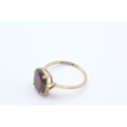 214 - 9ct gold oval claw set garnet ring (2.2g) Size P