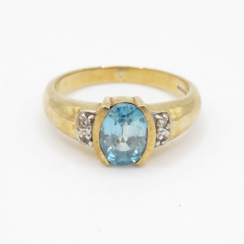 69 - 9ct gold oval cut blue gemstone dress ring w/ why gemstone set shoulders (3.5g) Size N