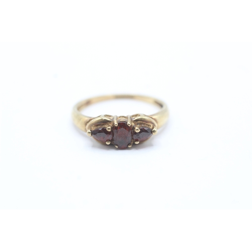 133 - 9ct gold vari-cut garnet trilogy ring (2.2g) Size Q