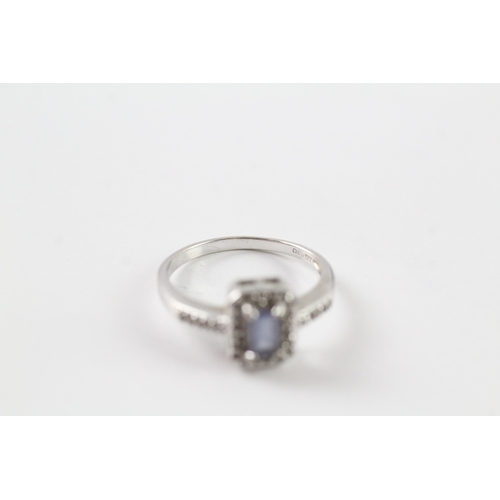 73 - 9ct white gold blue gemstone and diamond halo dress ring w/ diamond set shoulders (2.1g) Size L