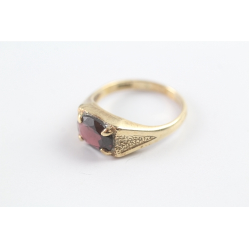 21 - 9ct gold vintage oval cut garnet dress ring with patterned shoulders (3.1g) Size N