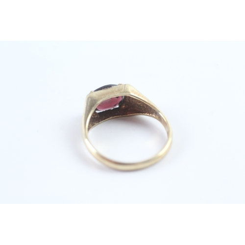 21 - 9ct gold vintage oval cut garnet dress ring with patterned shoulders (3.1g) Size N