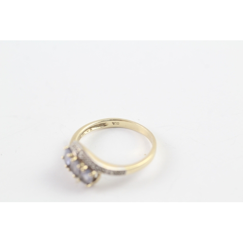 147 - 9ct gold diamond and tanzanite twist ring (2.8g) Size P