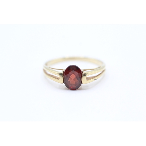 173 - 9ct gold oval cut garnet dress ring with split shoulders (2g)