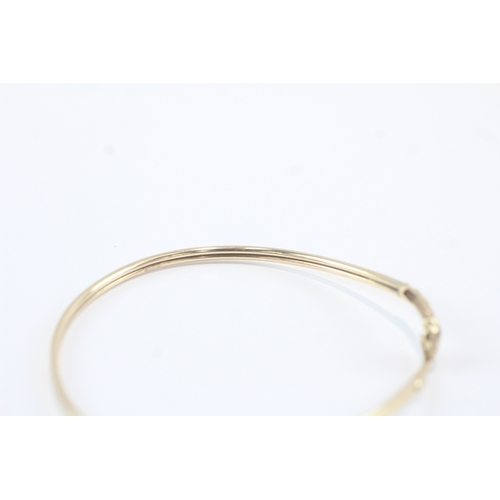 140 - 9ct gold garnet eyed snake bangle (4.9g)