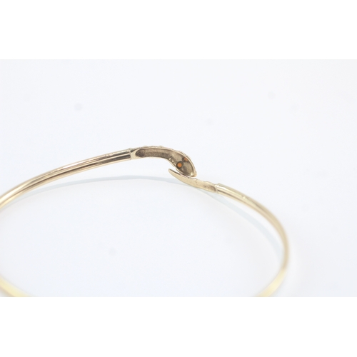 140 - 9ct gold garnet eyed snake bangle (4.9g)