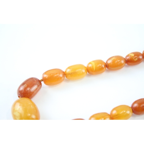 122 - 9ct gold clasped amber beaded necklace (26.3g)