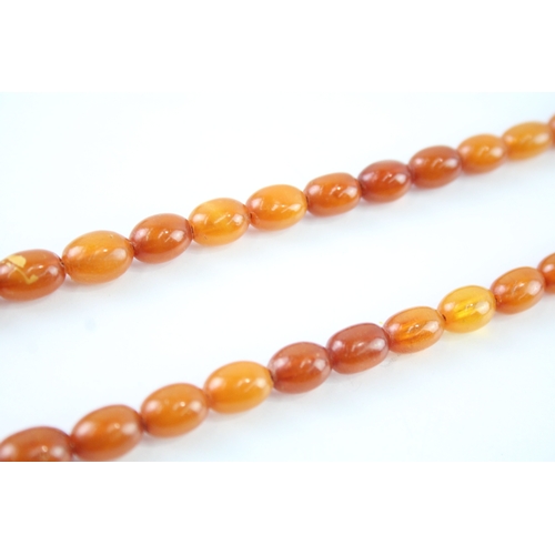 122 - 9ct gold clasped amber beaded necklace (26.3g)