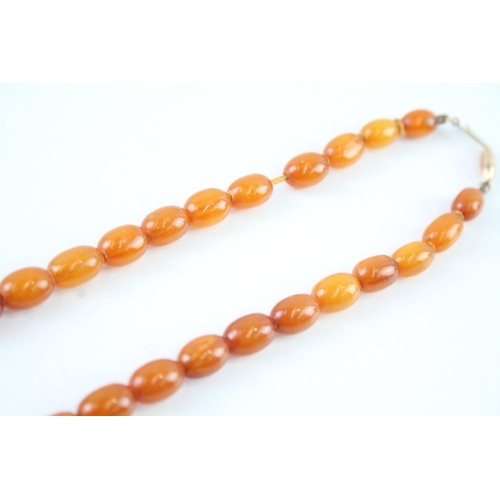 122 - 9ct gold clasped amber beaded necklace (26.3g)