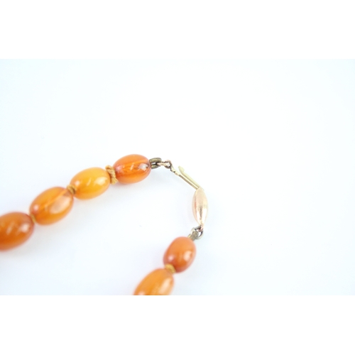 122 - 9ct gold clasped amber beaded necklace (26.3g)